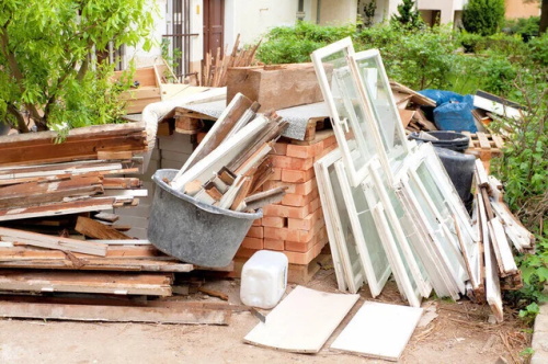 Demolition debris pile with wood, bricks, and old windows