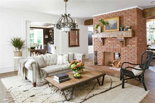 Cozy living room with brick fireplace and tufted sofa