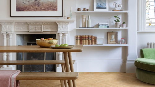 Bright dining room with carved fireplace and wooden table