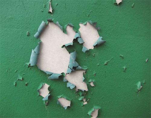 Green paint peeling off a wall