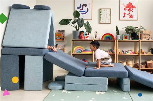 Child playing on modular blue foam play couch