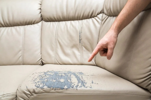 Damaged leather sofa seat with peeling paint