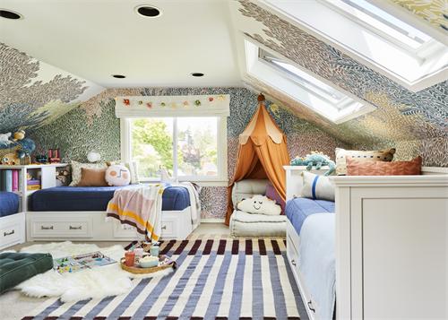 Attic kids' bedroom with twin beds, patterned wallpaper, and teepee tent