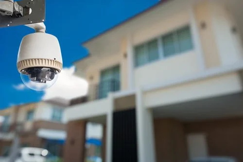 Outdoor dome-style security camera mounted near a residential building